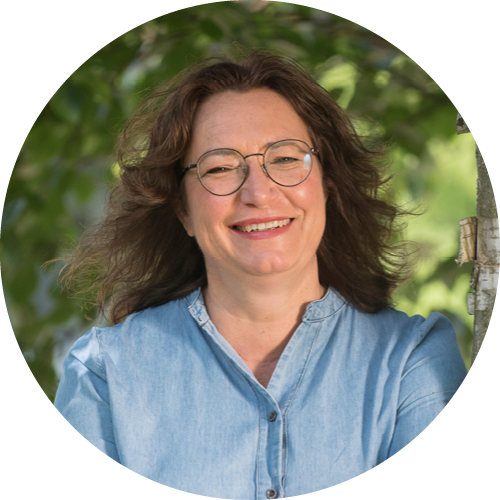 Kollegin steht neben einem Baum Protrait