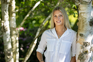 Junge Frau lehnt am Baum
